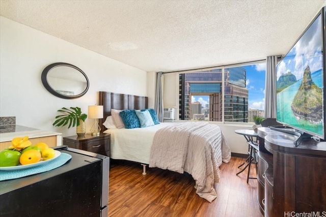 bedroom featuring dark wood-style flooring, a textured ceiling, and cooling unit