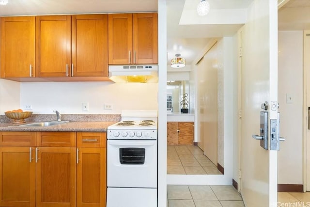 kitchen featuring electric range, light countertops, under cabinet range hood, a sink, and light tile patterned flooring