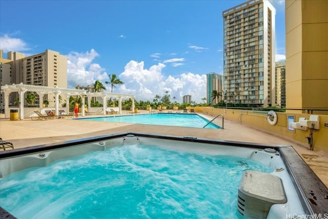 view of pool with a city view and a pergola