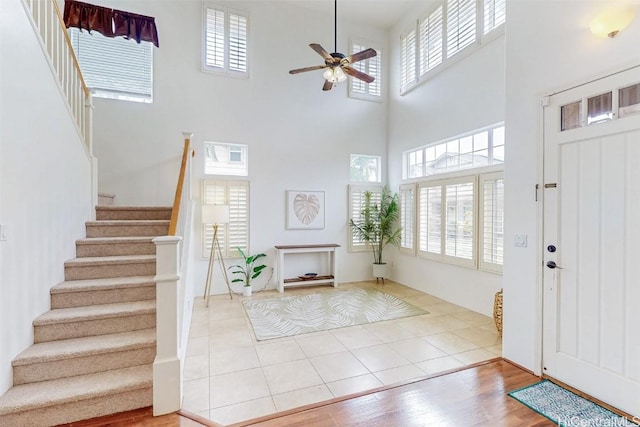 entryway featuring stairs, a ceiling fan, and tile patterned floors