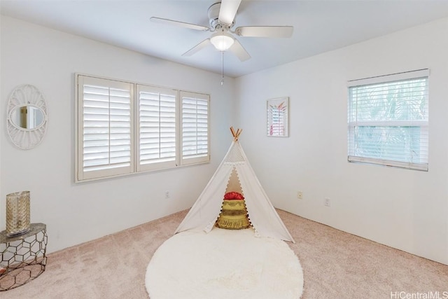 recreation room with carpet flooring, plenty of natural light, and ceiling fan