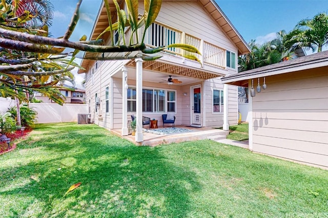 rear view of house with a patio, a balcony, central air condition unit, fence, and a lawn