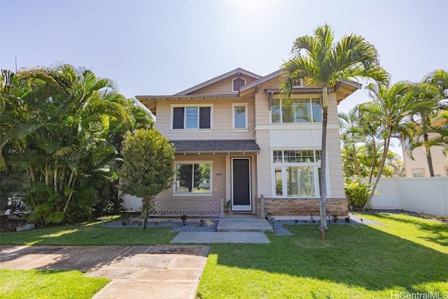 view of front of home featuring roof with shingles, fence, and a front yard