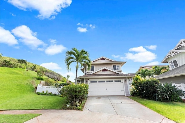 view of front of property with concrete driveway, fence, and a front lawn