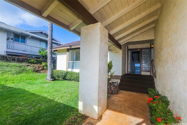 doorway to property featuring stucco siding and a lawn