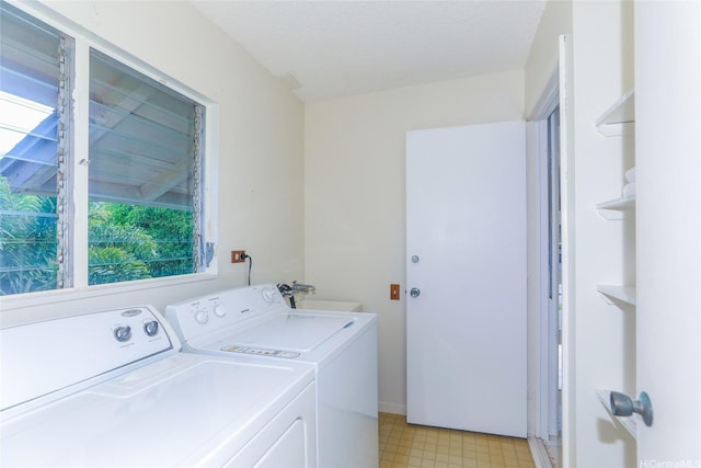 washroom featuring light floors, a sink, laundry area, and washing machine and dryer