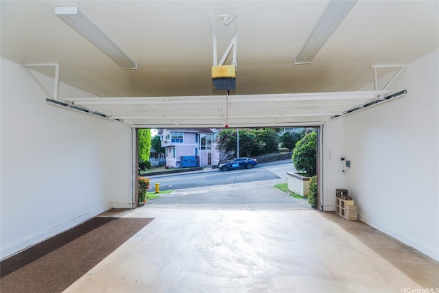 garage featuring a garage door opener and baseboards