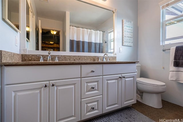 full bathroom with a sink, toilet, and double vanity