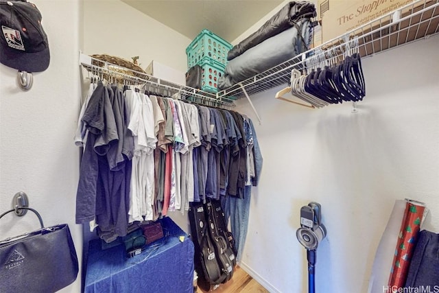 walk in closet with wood finished floors