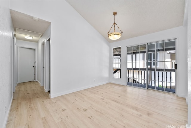 unfurnished room with vaulted ceiling, baseboards, and wood finished floors