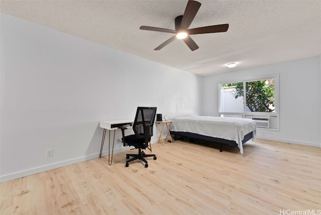 bedroom featuring a textured ceiling, ceiling fan, wood finished floors, and baseboards