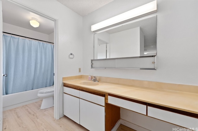 full bathroom featuring toilet, shower / bath combo, a textured ceiling, vanity, and wood finished floors