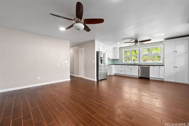 unfurnished living room with dark wood-style flooring, recessed lighting, a ceiling fan, a sink, and baseboards