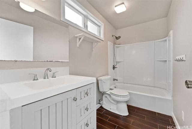 bathroom with baseboards, toilet, shower / tub combination, vanity, and wood finish floors