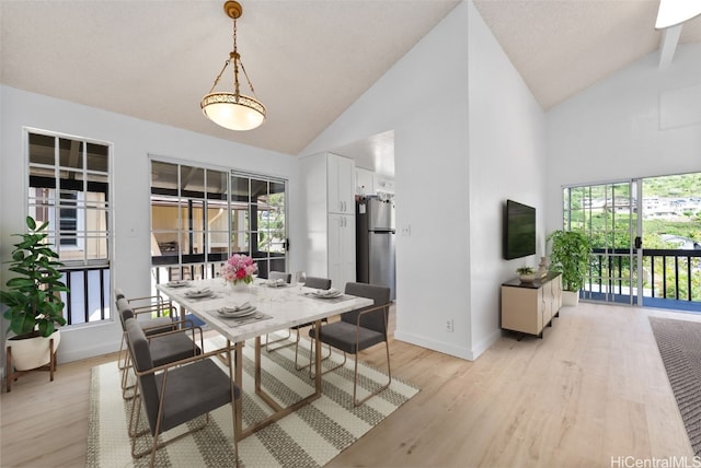 dining space featuring light wood-type flooring, high vaulted ceiling, and baseboards