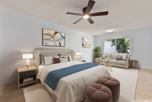 bedroom featuring a ceiling fan, a textured ceiling, baseboards, and wood finished floors