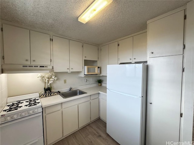 kitchen with white appliances, sink, white cabinetry, a textured ceiling, and light hardwood / wood-style floors