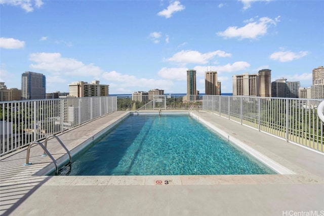 community pool featuring a view of city and fence