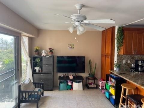 living area featuring light tile patterned floors and ceiling fan