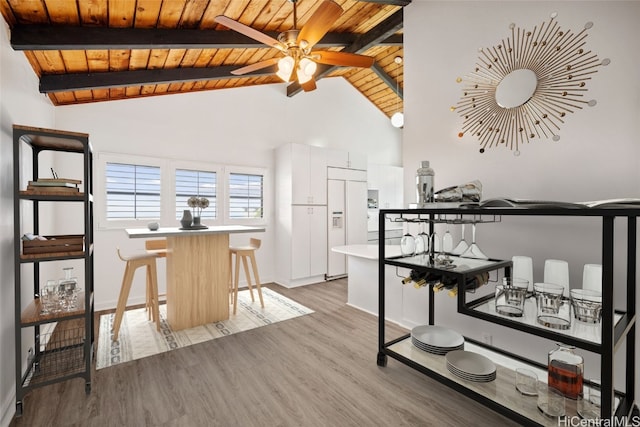 dining room with ceiling fan, wood ceiling, beam ceiling, wood finished floors, and high vaulted ceiling