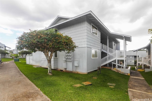 view of home's exterior featuring stairway and a lawn