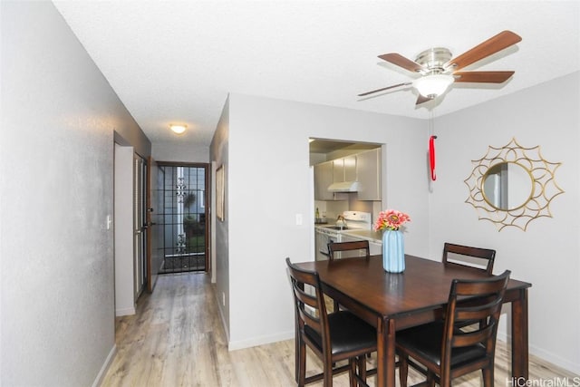 dining area with a ceiling fan, light wood-style flooring, and baseboards