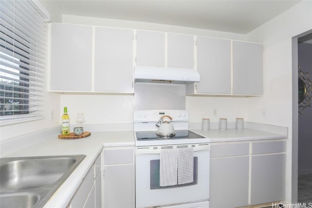 kitchen featuring light countertops, under cabinet range hood, white cabinetry, and electric range