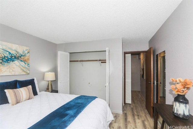 bedroom featuring a textured ceiling, a closet, and wood finished floors