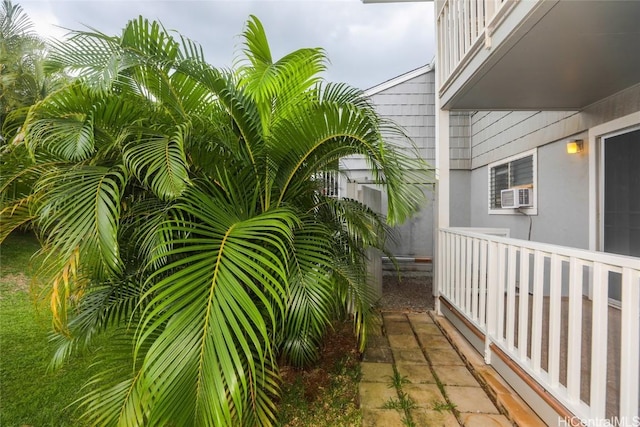 view of side of home featuring cooling unit, a balcony, and stucco siding