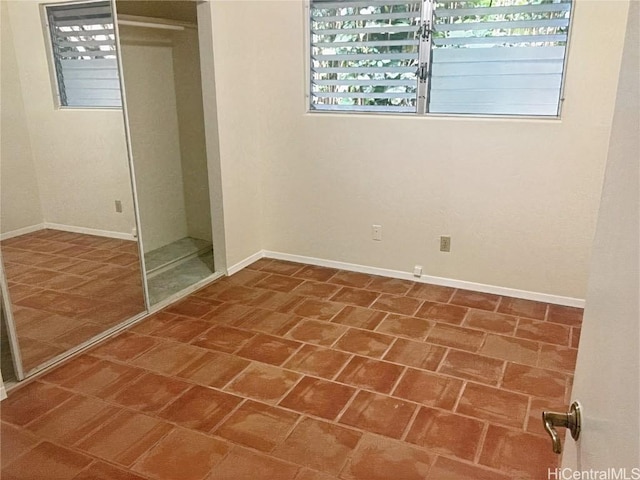 unfurnished bedroom featuring a closet and baseboards