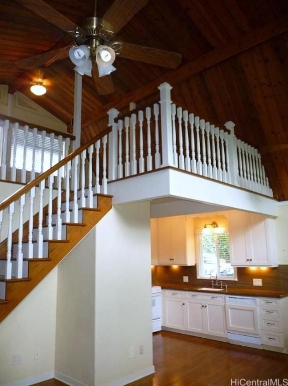 stairs featuring beam ceiling, high vaulted ceiling, a ceiling fan, wood finished floors, and wooden ceiling