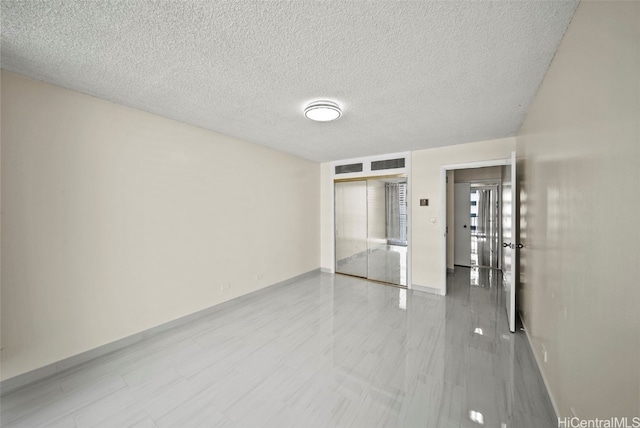 unfurnished room with visible vents and a textured ceiling