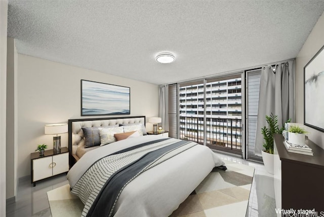 bedroom with a textured ceiling, a wall of windows, and access to exterior