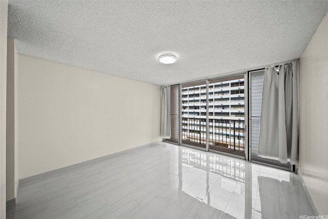 1561 Kanunu St Unit 801, Honolulu, HI 96814 - empty room with a wall of windows, a textured ceiling, and baseboards