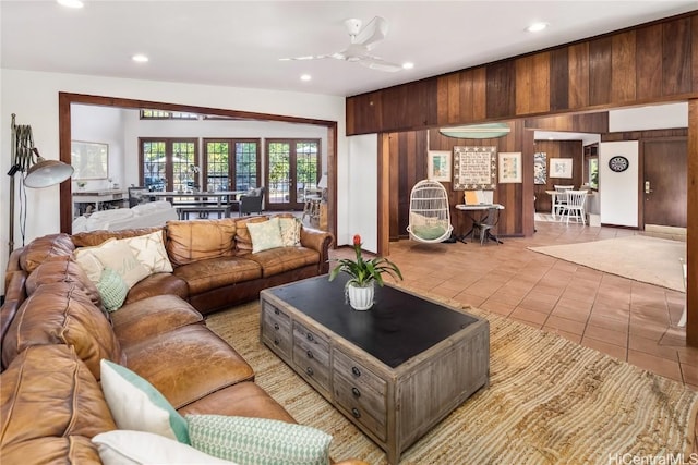 living area with light tile patterned floors, ceiling fan, wooden walls, and recessed lighting