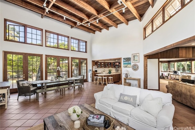 living area with beamed ceiling, dark tile patterned floors, and wood ceiling