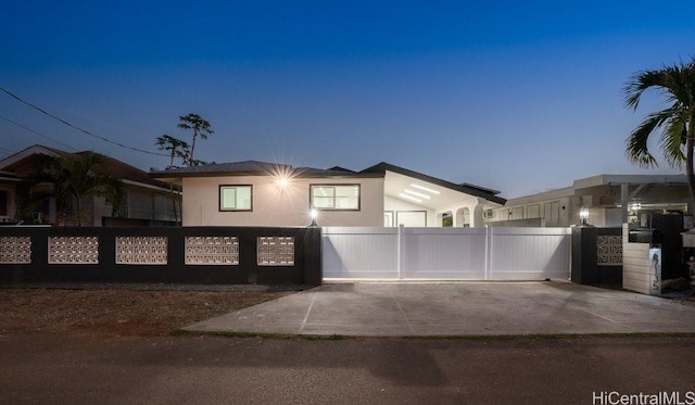 view of front of house featuring stucco siding, fence, and a gate