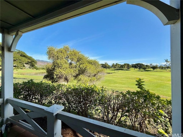 view of yard with view of golf course and fence