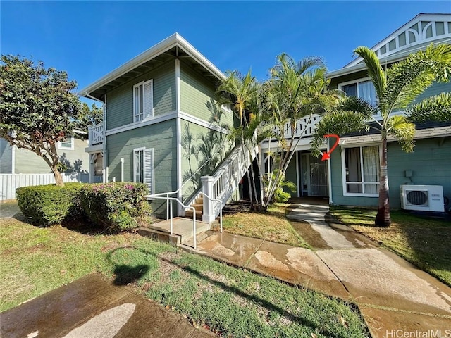 view of front of home with ac unit, a front yard, and fence