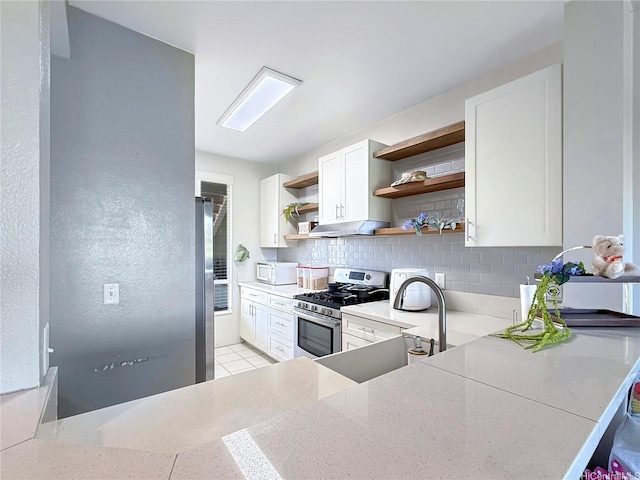 91-1058 Kekuilani Loop Unit 1502, Kapolei, HI 96707 - kitchen featuring stainless steel appliances, open shelves, decorative backsplash, light stone countertops, and white cabinets