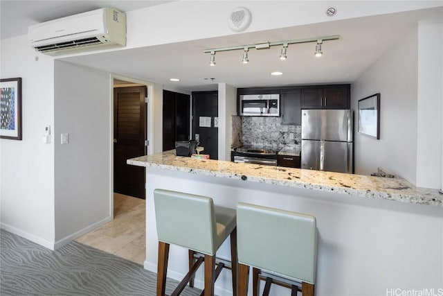 1777 Ala Moana Blvd Unit 2208, Honolulu, HI 96815 - kitchen featuring light stone counters, a breakfast bar, stainless steel appliances, a wall mounted air conditioner, and a peninsula