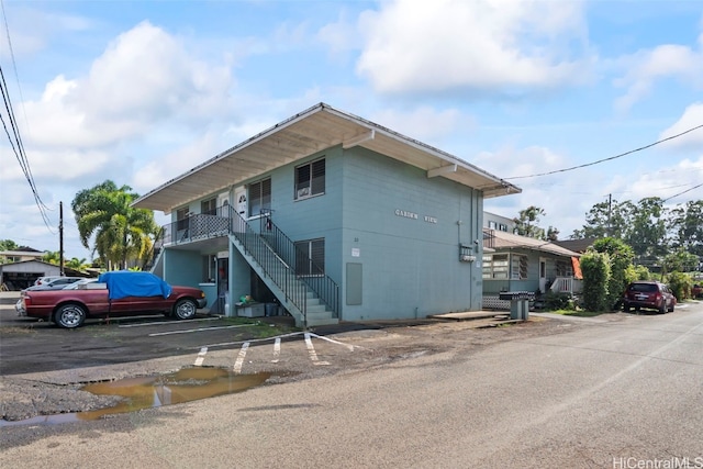 exterior space featuring uncovered parking and stairway