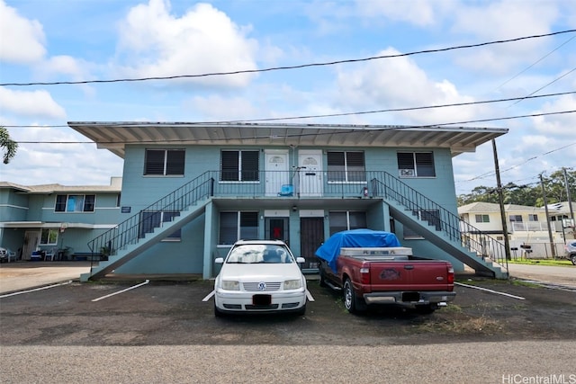 townhome / multi-family property featuring uncovered parking and stairway