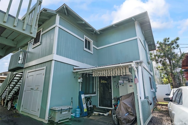 view of side of property with fence and stairway