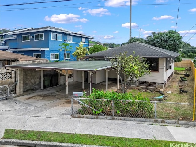 view of front of property with a carport, concrete driveway, and fence