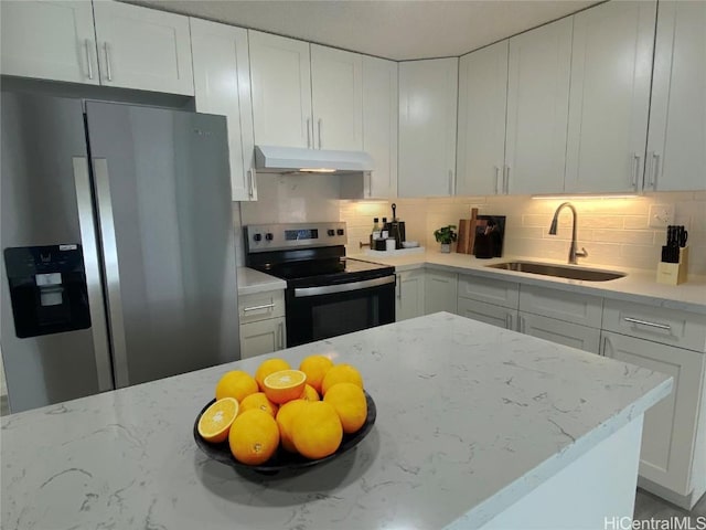 kitchen with under cabinet range hood, white cabinetry, appliances with stainless steel finishes, and a sink