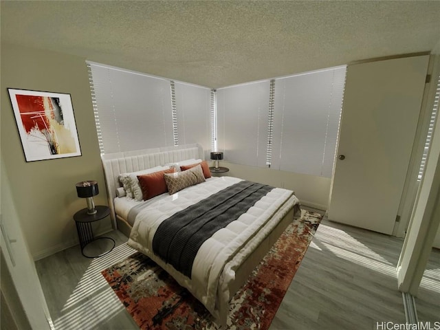 1060 Kamehameha Hwy Unit 702A, Pearl City, HI 96782 - bedroom with a textured ceiling, wood finished floors, and baseboards