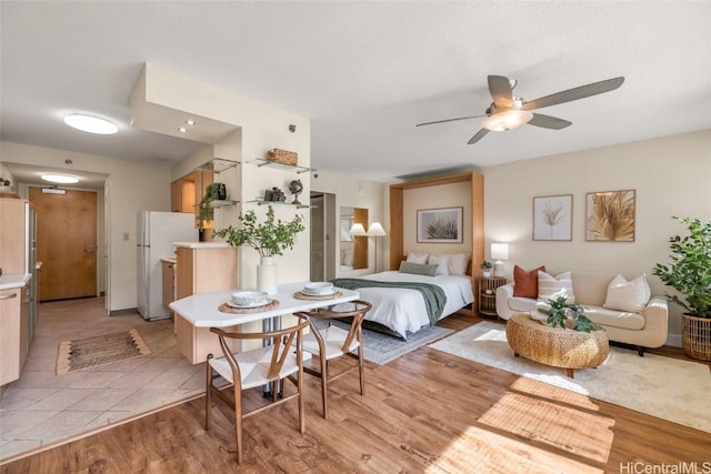 bedroom with white refrigerator and light hardwood / wood-style flooring