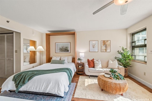 bedroom with a textured ceiling, a closet, hardwood / wood-style flooring, and ceiling fan