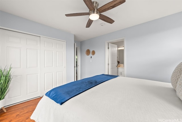 bedroom with a closet, wood finished floors, and a ceiling fan